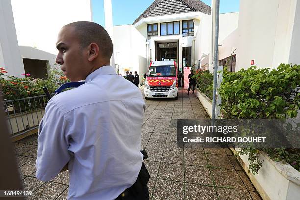 Policemen and firefighters stand at the entrance of the Champ-Fleuri courthouse in the Saint-Denis de la Reunion, on the French island of La Reunion,...