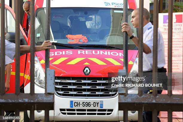 Firefigthers leave the Champ-Fleuri courthouse in the Saint-Denis de la Reunion, on the French island of La Reunion, after a man set himself on fire...