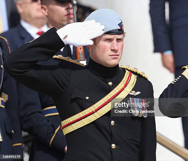 Prince Harry wearing his No. 1 ceremonial uniform of The Blues and Royals salutes as he pays his respects to the victims of the Afghanistan conflict...