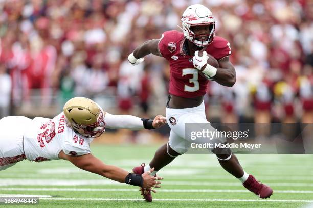 Trey Benson of the Florida State Seminoles runs the ball past Vinny DePalma of the Boston College Eagles during the first half at Alumni Stadium on...