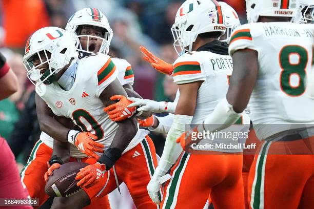 Te'Cory Couch of the Miami Hurricanes celebrates with teammates after intercepting a pass against the Temple Owls in the second half at Lincoln...