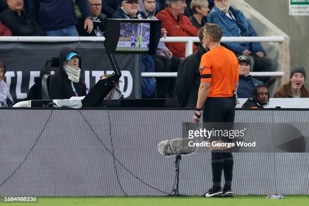 Match Referee Craig Pawson checks the VAR screen for potential hand ball during the Premier League match between Newcastle United and Brentford FC at...