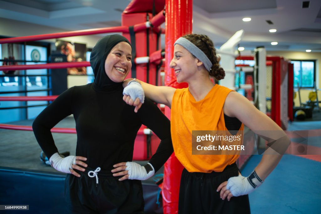 Middle Eastern females boxing in gym