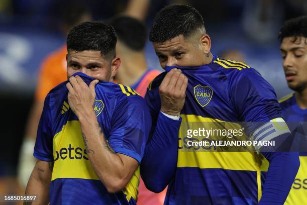 Boca Juniors' Colombian midfielder Jorman Campuzano and Boca Juniors' defender Marcos Rojo talk to each other as they leave the field after tying 1-1...