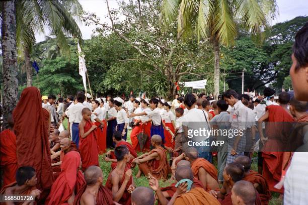 Buddhist monk and Burmese demonstrators arrive to listen to unseen opposition leader Aung San Suu Kyi, August 27, 1988 during a rally held in Yangon....