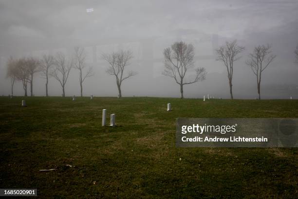 Landscape views, seen through the window of a bus shuttling family members to the grave site of relatives, of Hart Island, New York Citys burial...