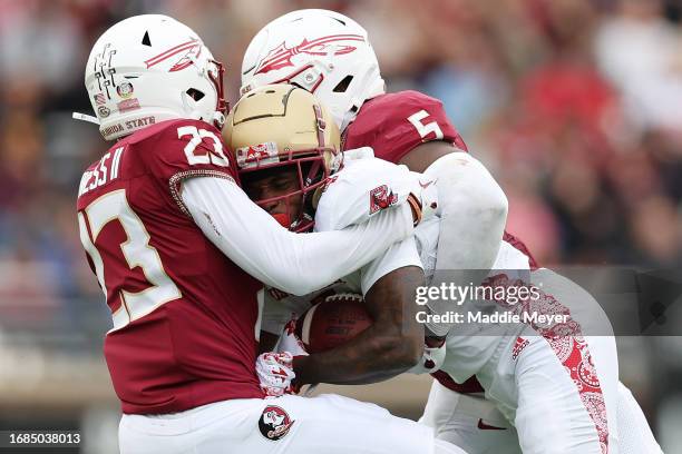 Ryan O'Keefe of the Boston College Eagles is tackled by Jared Verse and Fentrell Cypress II of the Florida State Seminoles during the second half at...