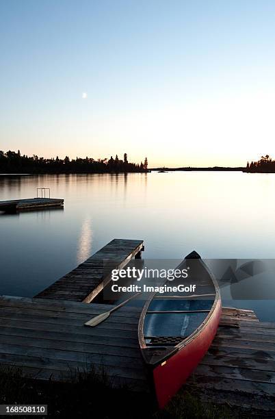 canoe by a dock at sunset - muskoka stockfoto's en -beelden