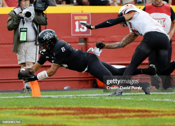 Running back Eli Sanders of the Iowa State Cyclones dives into the end zone for a touchdown as cornerback Korie Black of the Oklahoma State Cowboys...
