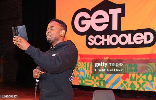 Kendrick Lamar takes a video of the crowd from the stage with his smartphone while visiting Providence, Rhode Island students with the Get Schooled...