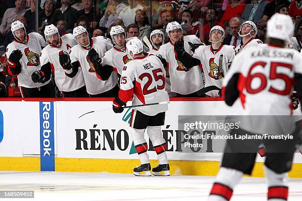 Chris Neil of the Ottawa Senators celebrates a goal at the bench with teammates against the Montreal Canadiens in Game Five of the Eastern Conference...