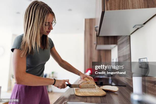 teenage girl is cutting bread - girl making sandwich stock pictures, royalty-free photos & images