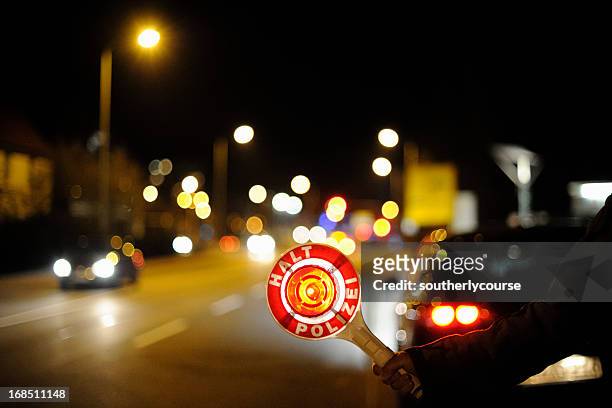 deutscher polizist stoppen den verkehr in der nacht - autostop stock-fotos und bilder