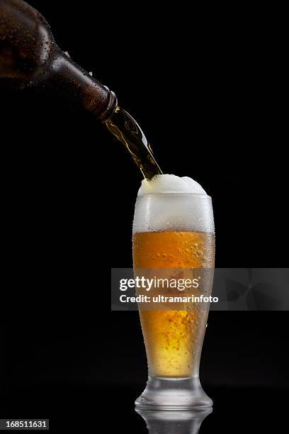 splashing - beer pour in glass - beer splash stock pictures, royalty-free photos & images