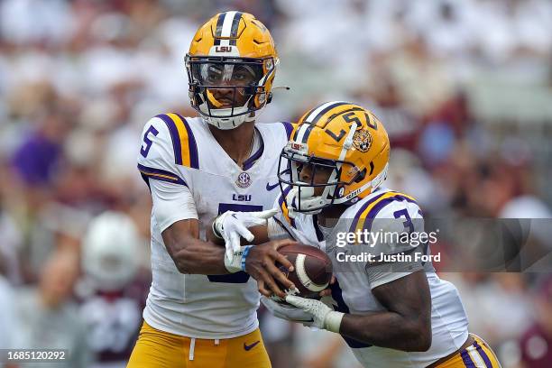 Jayden Daniels of the LSU Tigers hands the ball off to Logan Diggs during the second half against the Mississippi State Bulldogs at Davis Wade...