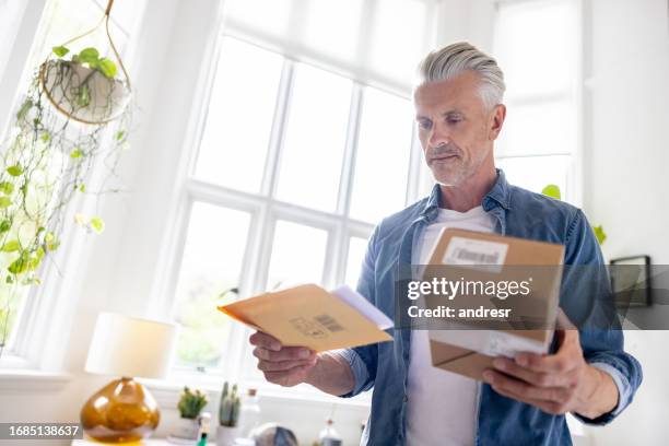man at home getting packages and letters in the mail - wrapping stock pictures, royalty-free photos & images