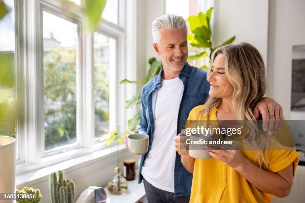 happy couple at home drinking a cup of coffee - woman drinking stock pictures, royalty-free photos & images