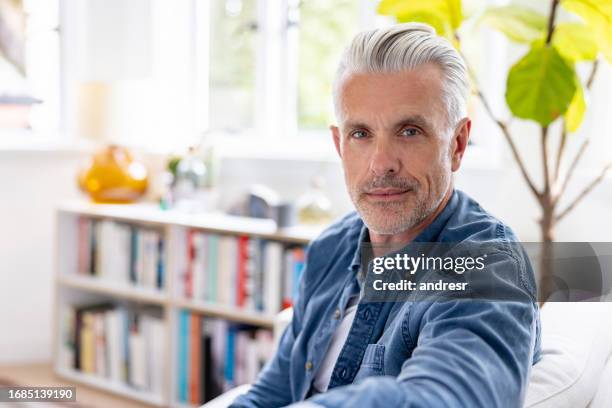 happy man sitting at home on the sofa - handsome people stock pictures, royalty-free photos & images