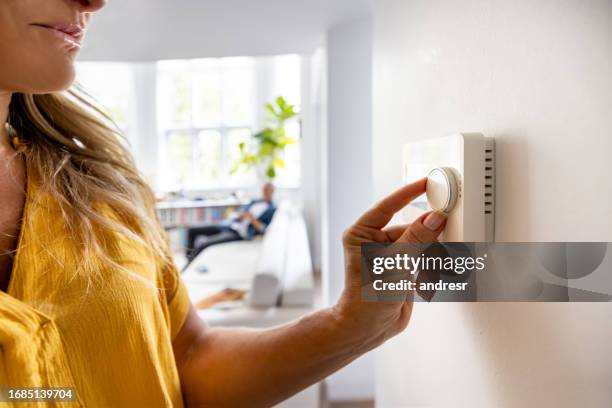 close-up on a woman adjusting the temperature with a dimmer - airconditioning stockfoto's en -beelden