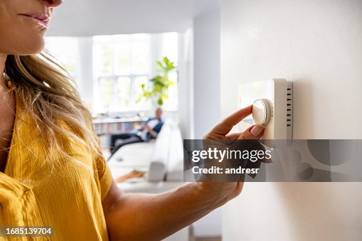 Close-up on a woman adjusting the temperature with a dimmer Close-up on a woman adjusting the temperature with a dimmer