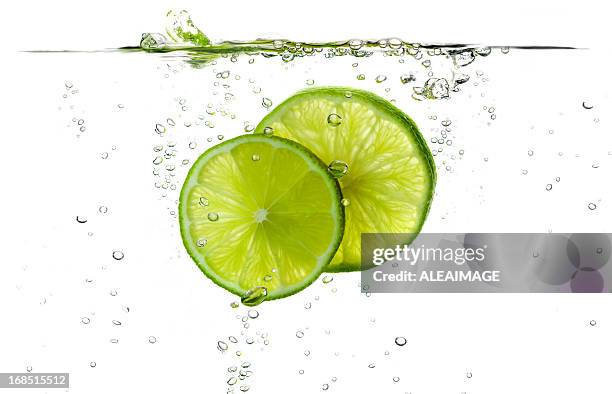 lime slices splashing in fresh water - lemon slice stock pictures, royalty-free photos & images