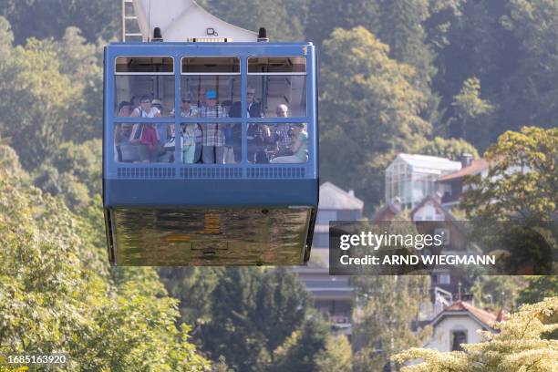 Tourist are seen in the cabin of the Pfanderbahn cable car network, manufactured by Austrian ropeway company Doppelmayr, on their way down from Mount...