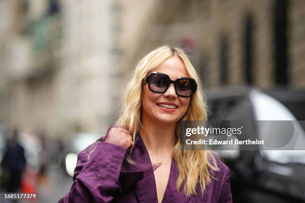 Guest wears a dark purple full outfit, an oversized blazer jacket, sunglasses, outside Jason Wu, during New York Fashion Week, on September 10, 2023...