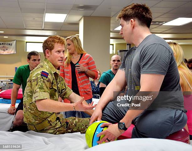Prince Harry talks to staff Sergeant Timothy Payne during his visit to the Military Advanced Training Center at Walter Reed National Military Medical...