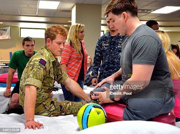 Prince Harry talks to staff Sergeant Timothy Payne during his visit to the Military Advanced Training Center at Walter Reed National Military Medical...
