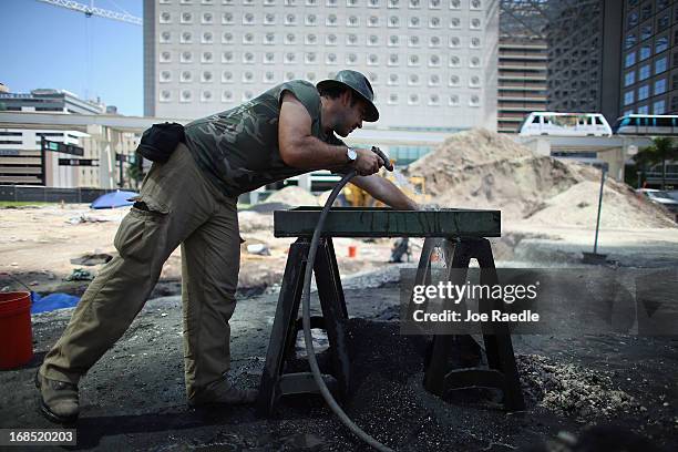 Archaeologists Oscar P. Pereira, with the Archaeological and Historical Conservancy, sifts through items on a sifting board while excavating a site...