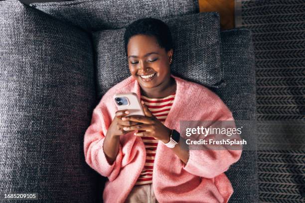 woman texting on her smartphone - cosy woman stock pictures, royalty-free photos & images