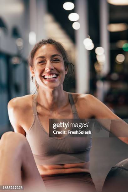 a happy beautiful sportswoman looking at camera after doing her daily workout in the gym - woman exercise imagens e fotografias de stock