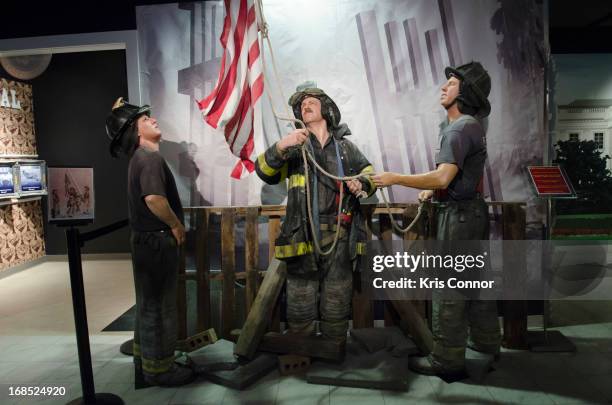 Wax figures of New York City firefighters raising the flag at ground zero are displayed during the Madame Tussauds "HOPE: Humanity And Heroism" 9/11...
