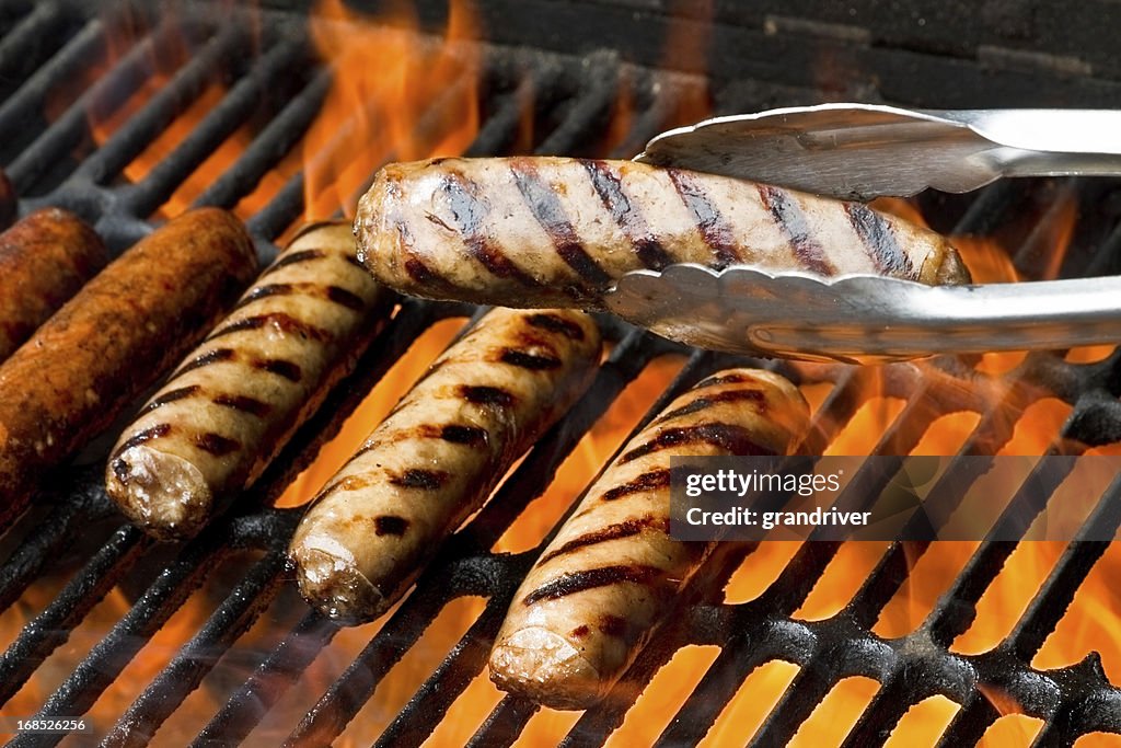 Bratwurst or Hot Dogs on Grill with Flames