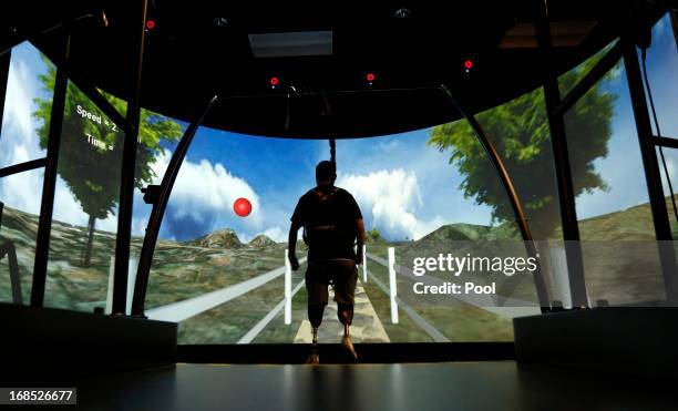 Wounded soldier with prosthetic legs uses a treadmill with a huge video screen as part of his rehabilitation at Walter Reed National Military Medical...