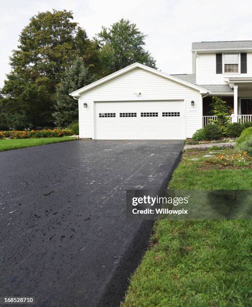 rain puddles on new asphalt driveway at residential home - garage driveway stock pictures, royalty-free photos & images