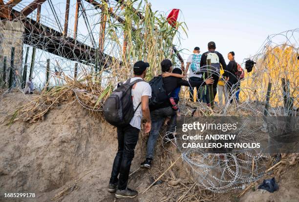 Migrants from Venezuela get out of the Rio Grande river as they climb the river bank at the US-Mexico border in Eagle Pass, Texas on September 23,...