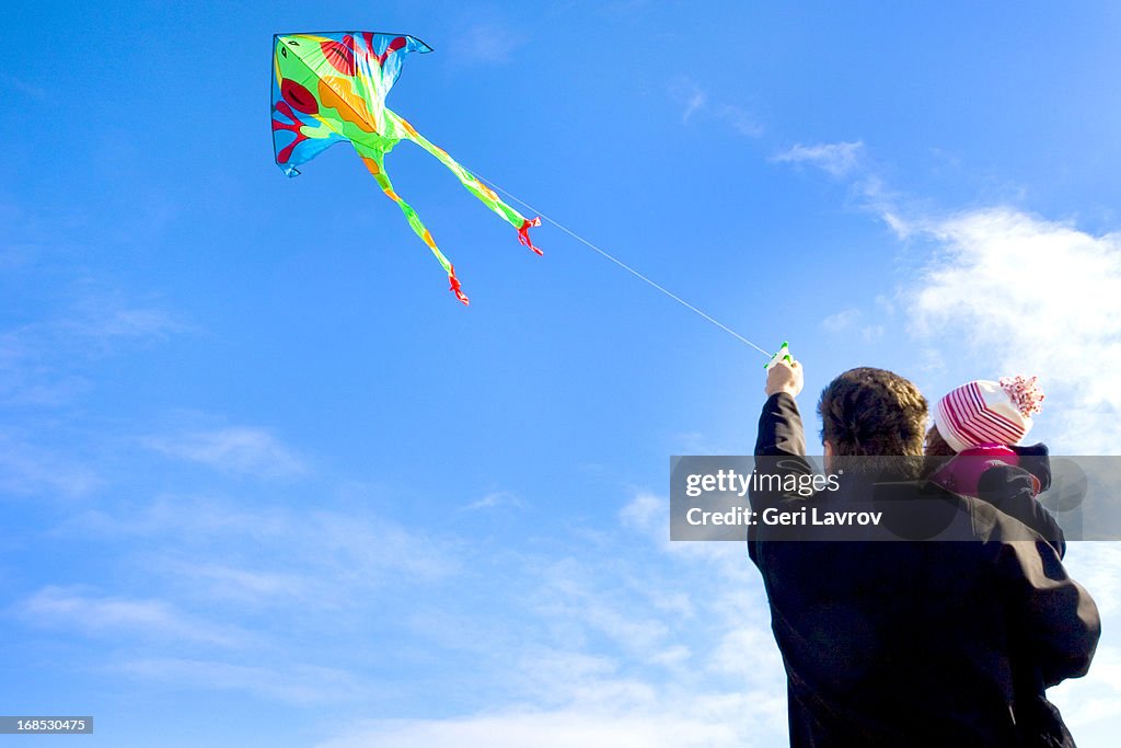 Father and daughter flying a kite together