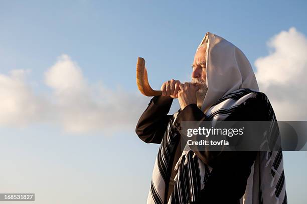 elder jewish man blowing a shofar on rosh hashanah - hasidic jew stockfoto's en -beelden