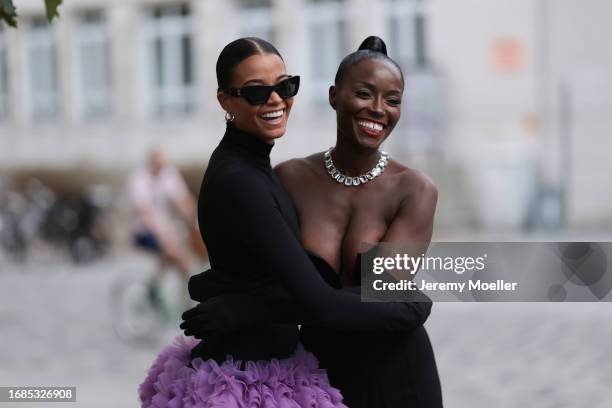 Ella Balinska is seen wearing silver hoop earrings, black sunglasses, a long-sleeved mini dress with turtleneck and purple tulle tutu with black...