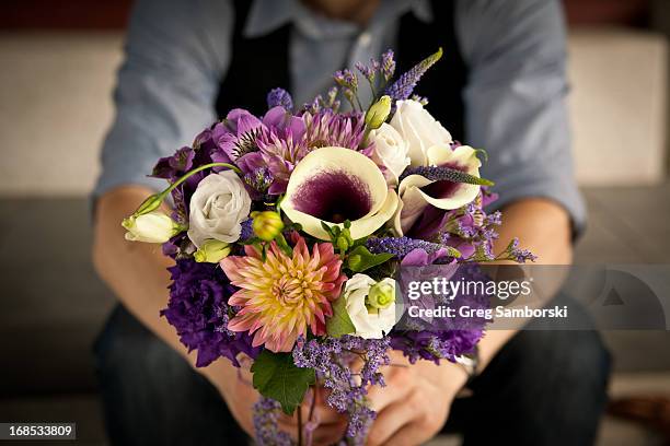 hands holding a bouquet of flowers - bouquet foto e immagini stock