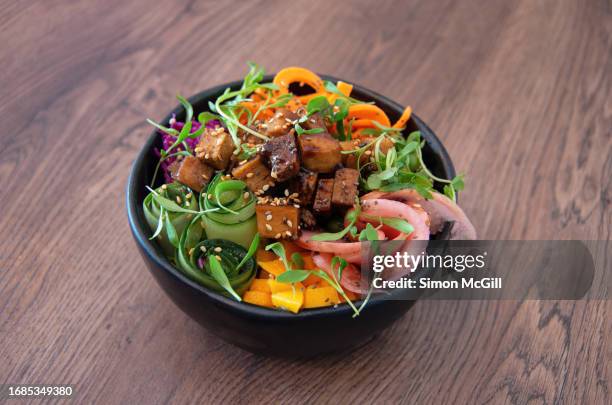 poke bowl of cold brown rice base, marinated tofu, pickled red cabbage and radishes, mango, grated carrot, cucumber, chia and sesame seeds & organic sprouts - mango pickle stock pictures, royalty-free photos & images