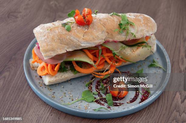vegetarian banh mi sandwich with smoked tofu, beetroot hummus and vietnamese-style pickled vegetables (carrot, radish, cucumber) - fusion food stock pictures, royalty-free photos & images