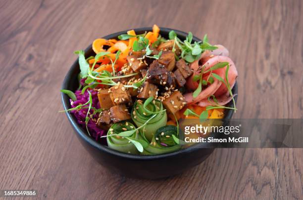 poke bowl of cold brown rice base, marinated tofu, pickled red cabbage and radishes, mango, grated carrot, cucumber, chia and sesame seeds & organic sprouts - mango pickle stock pictures, royalty-free photos & images