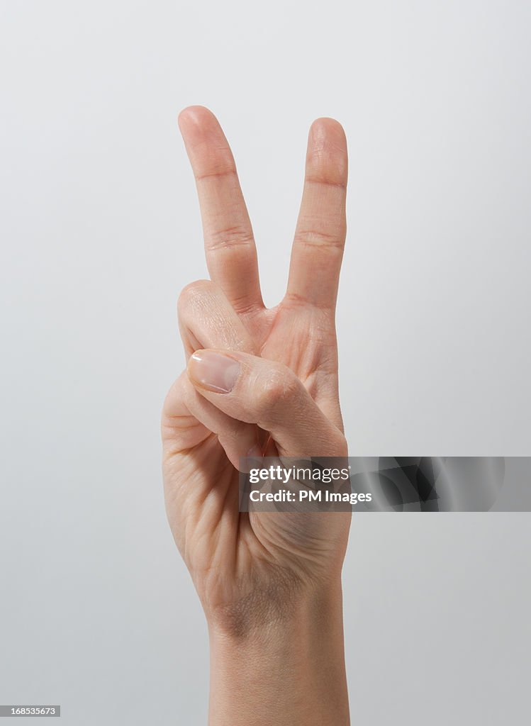 Woman's hand making peace sign