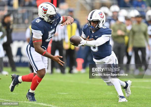 UConn Huskies quarterback Ta'Quan Roberson hands the ball off to DUPLICATE***UConn Huskies running back Jalen Mitchell during the game as the Duke...