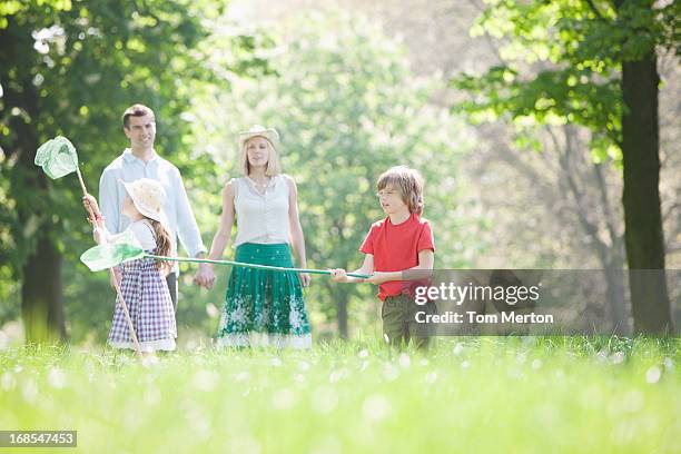 family playing in park - chasing butterflies stock pictures, royalty-free photos & images