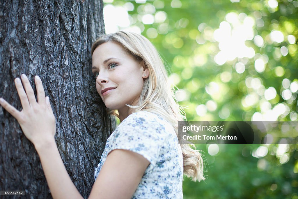 Mujer que abrazan árbol al aire libre