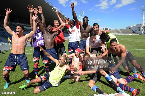 Monaco's players celebrate victory at the end of the L2 football union match between Nimes and Monaco at the Costieres Stadium on May 11, 2013 in...