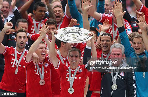 Philipp Lahm of FC Bayern Muenchen lifts the Bundesliga trophy following his team's match against Augsburg at the Allianz Arena on May 11, 2013 in...